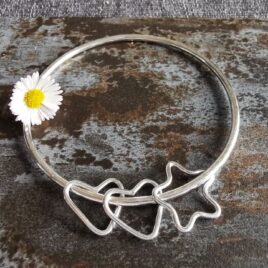 sterling silver bangle with 3 charms on slate